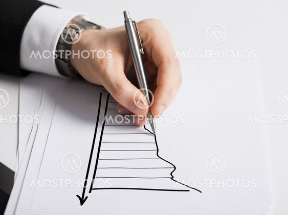 close up of male hand with pen drawing graph