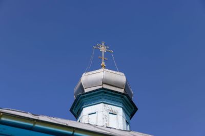 wooden christian cross on a blue sky background