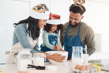 Christmas, parents and child with baking in kitchen for...