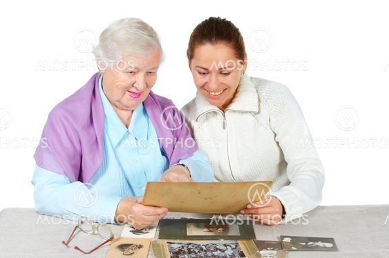 Grandmother with granddaughter looks old family photos.