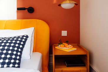 Close-up of a wooden laconic bedside table with books...