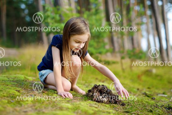 Adorable little girl hiking in the forest