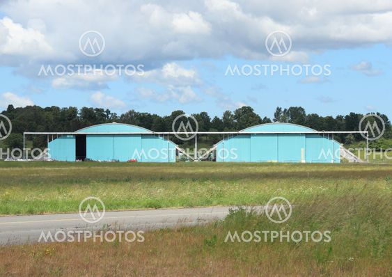 Airplane hangar isolated at airfield with clouds