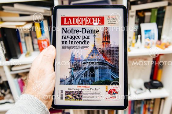 Man reading on iPad Pro about Notre-Dame de Paris fire