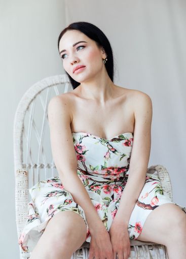 Beautiful brunette woman in summer dress with flowers on...