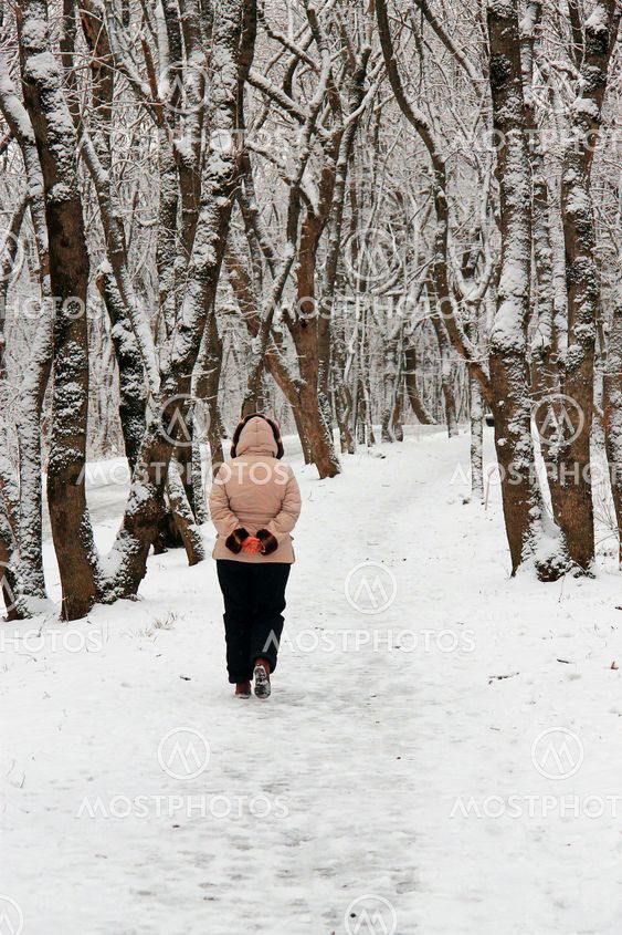 Woman walking alone in the winter park outdoor