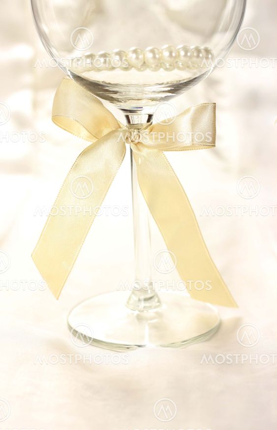 Wineglass with ribbon on silk fair background