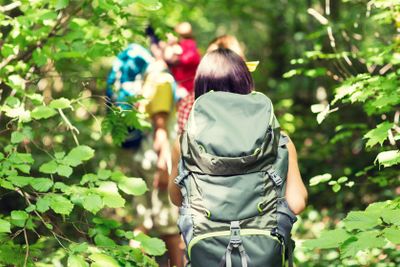 close up of friends with backpacks hiking