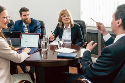 Confident business people smiling while listening to...