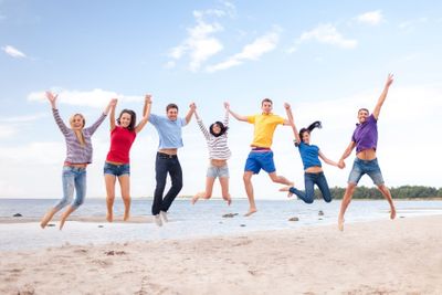 group of friends jumping on the beach