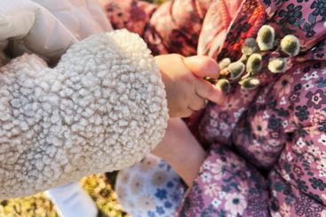 Close-up of child holding willow branches outdoors in...