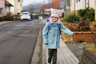Cute little girl o the way to or from school. Healthy...