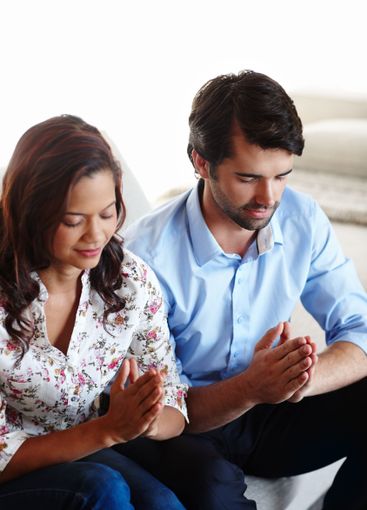 Christian, worship and couple praying in home for calm...