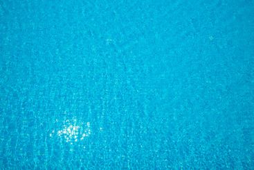 Bright sparkling blue water in a pool reflecting...