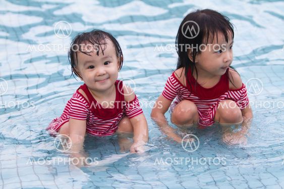Two Little Sisters Playing in Water