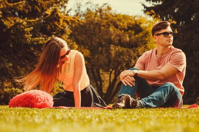 Moody girl with boyfriend in park. 