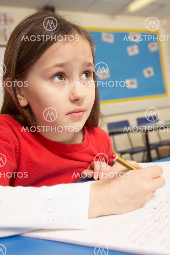 Stressed Schoolgirl Studying In Classroom