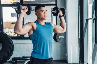 concentrated young asian sportsman exercising with...