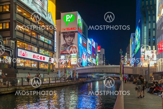 Osaka, Japan - April 2016: Tourist popular night shopping scene in Osaka City at Dotonbori Namba area with illuminated neon signs and billboards along the river