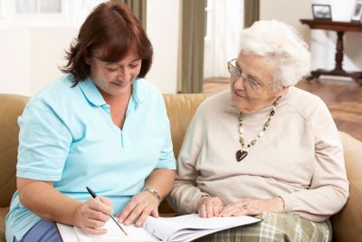 Senior Woman In Discussion With Health Visitor At Home