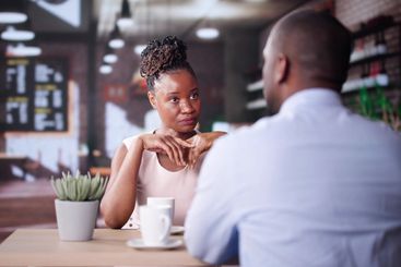 Laughing Male And Female Sitting In Cafe Drinking Coffee