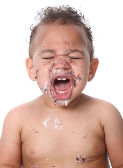 Sweet baby boy eating birthday cake