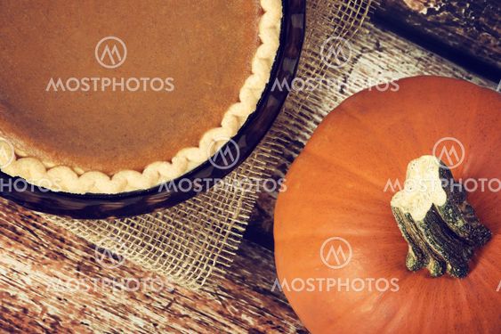 Pumpkin pie with a pumpkin on wooden vintage table
