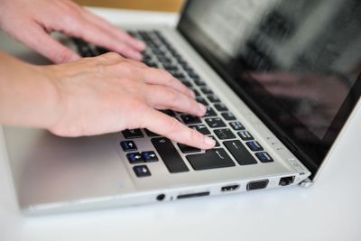 close up female hands on lap top computer