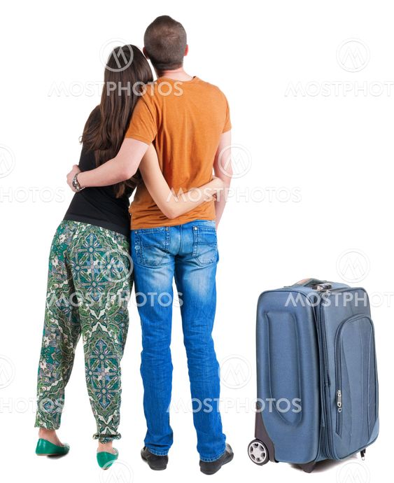 Back view of young couple traveling with suitcas .