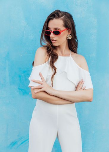 Beautiful Brunette Woman in White Suit on Blue Background