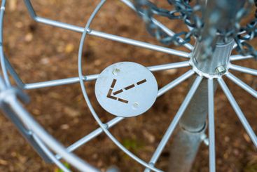 Arrow on the bottom of a disc golf target marking the...