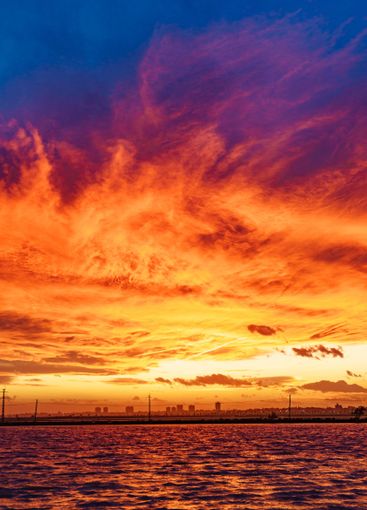 Sea coast and city skyline at sunset, Spain