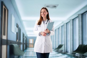 Female surgeon consulting with staff in hospital corridor
