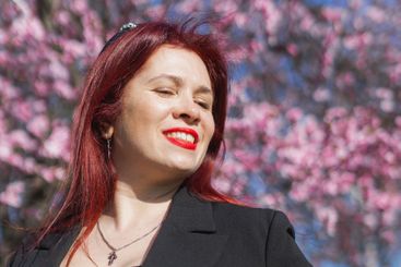 Woman with cherry flowers surrounded by blossoming trees...
