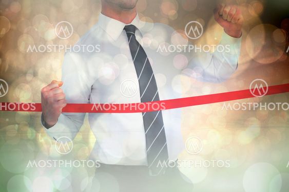 Composite image of businessman crossing the finish line