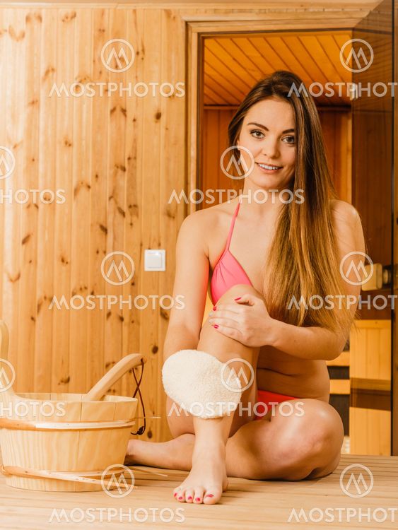 Woman in sauna with exfoliating glove. Skincare.