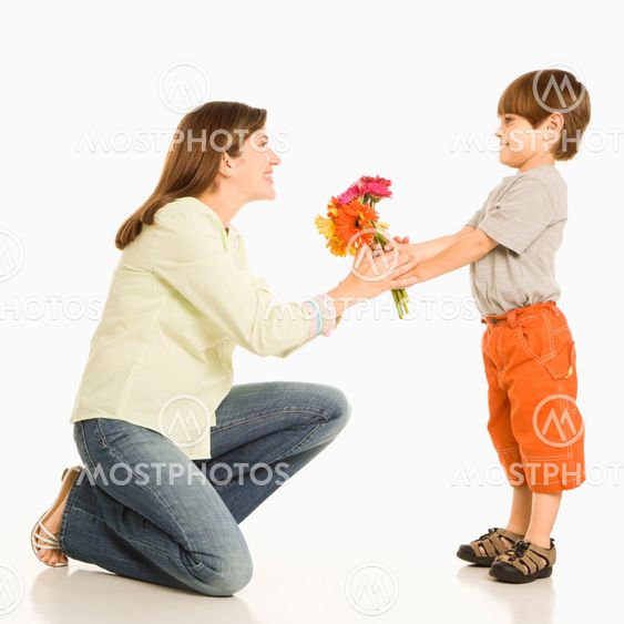 Boy giving mother flowers.