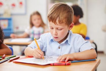 Boy child, school and coloring in classroom for creative...
