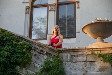 Beautiful woman in a red dress near an old building