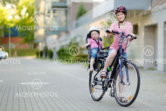 Young mother and her toddler girl riding a bicycle