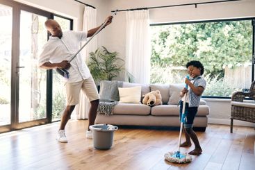 Playing, child and man with broom, home and fun with...