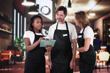 Busy Coffee Shop Owner Smiling as Meeting