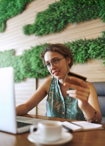 Cafe, happy and businesswoman with laptop for credit...