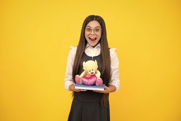 Funny school girl with toy. Happy childhood and kids...