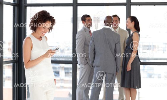 Afro Businesswoman holding a phone at workplace with his colleagues