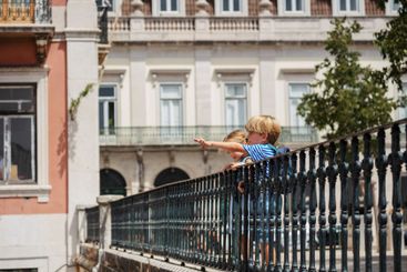 Young travelers at Lisbon viewpoint pointing with fingers