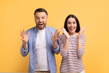 Couple sharing joyful moment together in front of bright...