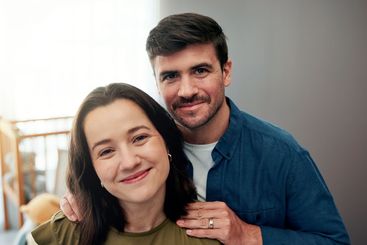 Portrait, smile and love with couple in nursery for...