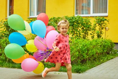 happy little girl outdoors with balloons