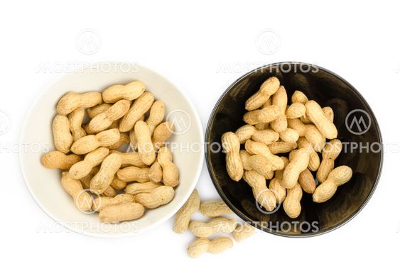 Black and white bowls full of peanuts on a white background